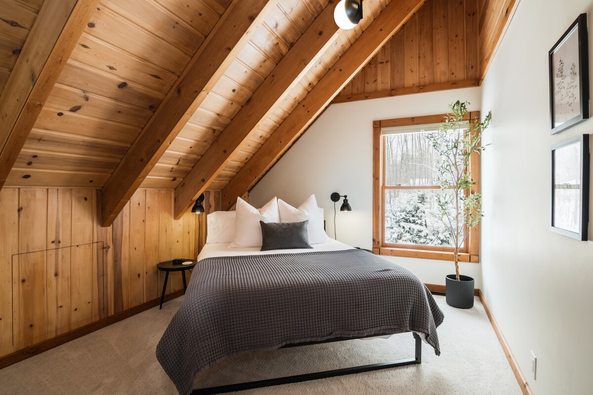 Upstairs queen bedroom with wood-beamed ceiling